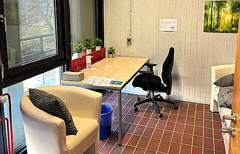 Blick auf einen Sessel und einen Schreibtisch vor einem Fenster